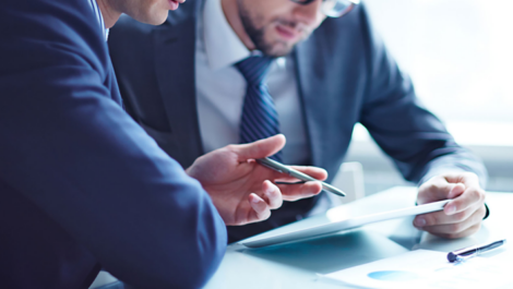director of finance looking over documents with another man in a suit