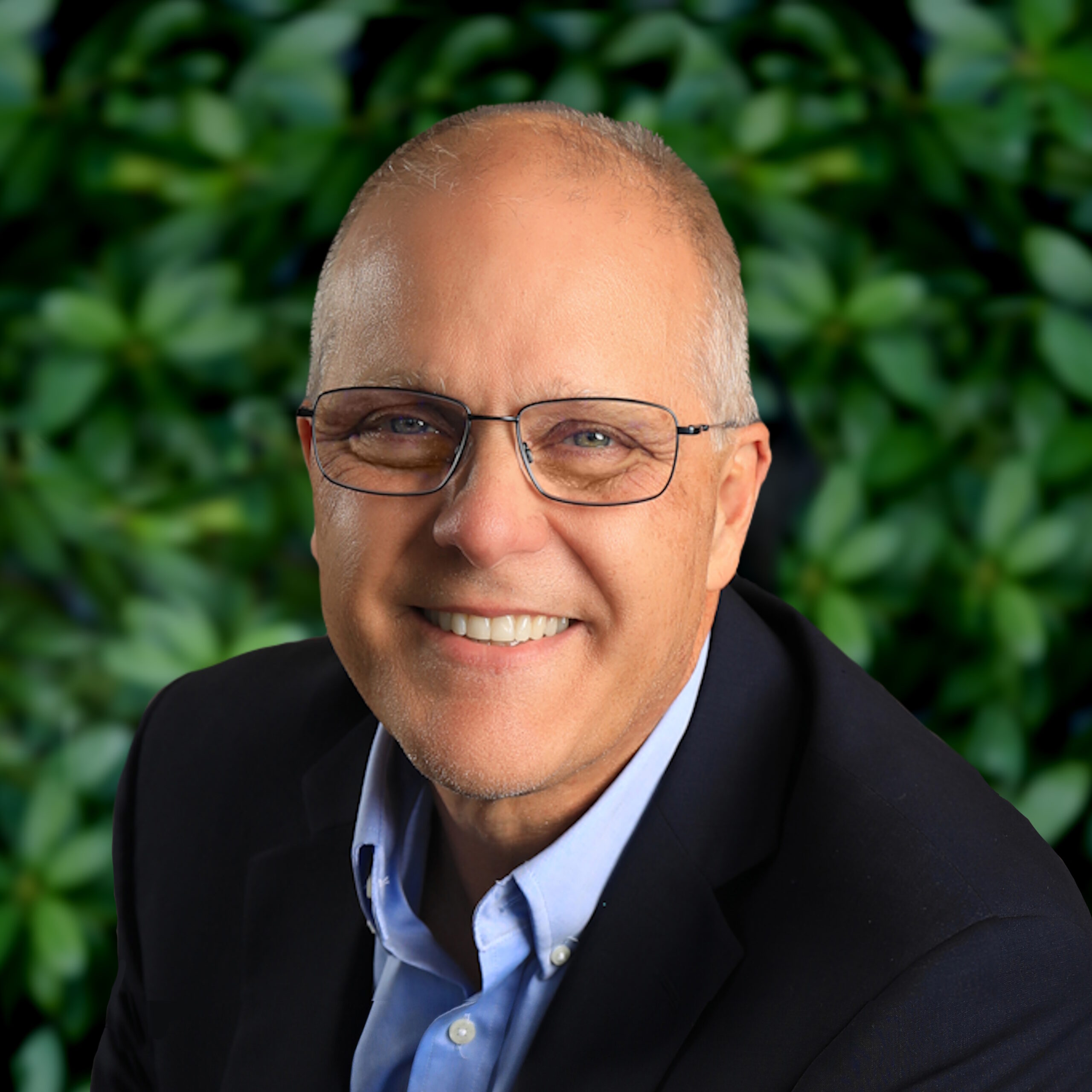 Blue-eyed smiling man wearing glasses and a blue suit