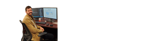 Bearded man at a computer smiling